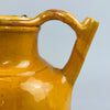 Surface detail shot showing glaze loss on the antique yellow pitcher, revealing red clay beneath, adding character and historical depth to this French provincial pottery piece, ideal for collectors of patinated ceramic vessels.