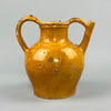 Antique French gargoulette water jug made of terracotta with vibrant yellow glaze, twin handles, and side spout, ideal as a rustic farmhouse accent or vintage Mediterranean pottery display in traditional or eclectic home settings.