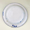 Antique cobalt Manises plate showing the direct hand of the decorator through variations in brush pressure, line width, and glaze saturation. The white earthenware ground is covered by a dense geometric lattice around the rim and a restrained central composition of botanical and grid symbols. The signed Spanish wall plate retains rim chips and fritting.