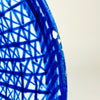 Antique Manises majolica charger with a large circular form, shallow well, and broad decorated rim. Saturated cobalt brushwork creates a woven lattice of intersecting lines, surrounding a white central reserve with simplified foliage and geometric marks. A visible signature and natural edge wear distinguish this Spanish ceramic wall plate.