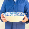 Blue green Fajalauza bowl with hand painted Granada pottery decoration, combining a bold cobalt rim, geometric lattice center, and repeated green brush marks. The large ceramic bowl is designed for wall display or tabletop styling and works well with rustic home decor, vintage kitchen decor, and Mediterranean ceramic collections.
