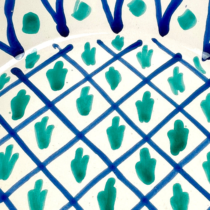 Fajalauza ceramic bowl from Granada style pottery, decorated with loose cobalt blue lines and green vegetal marks arranged within a grid pattern. The hand painted surface, blue rim, and deep lebrillo form make it useful as a decorative wall bowl, ceramic centerpiece, or Spanish pottery accent for cottage decor and rustic home decor.