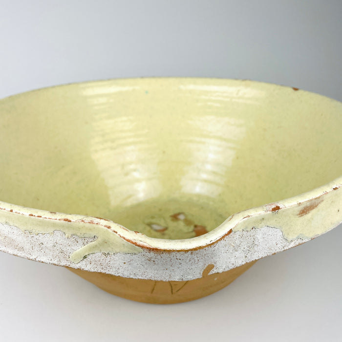 Antique French terracotta tian bowl, showing the softly mottled pale yellow glaze, fine speckling, subtle blue-green flecks, and wheel-thrown ridges beneath the finish. These handmade variations and time-softened surface are characteristic of rustic provincial pottery and complement wabi sabi decor and Mediterranean decor.