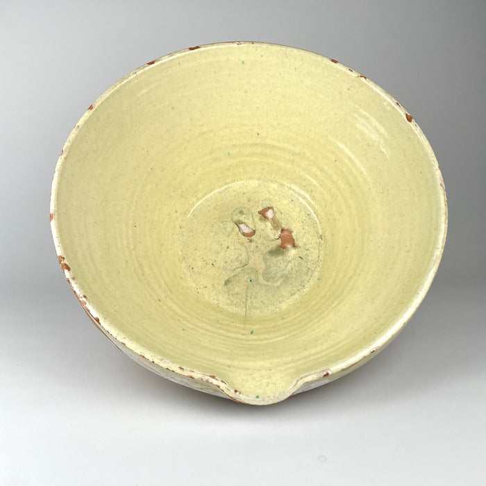 Large early 1900s Provence tian bowl in French terracotta, with a softly yellow glazed interior and broad rim above a substantial unglazed ochre body. The surface shows chips, rubbing, glaze losses, and handmade irregularities consistent with long use, while the simple utilitarian silhouette works naturally with rustic home decor and Mediterranean decor.