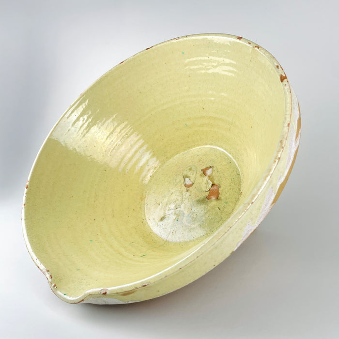 Interior base detail of a large antique French terracotta tian bowl, showing concentrated glaze losses, worn patches, fine surface marks, and exposed reddish clay at the center. The surrounding pale yellow glaze retains visible wheel rings and age variation, creating the strongly timeworn surface associated with antique Provence pottery and wabi sabi decor.