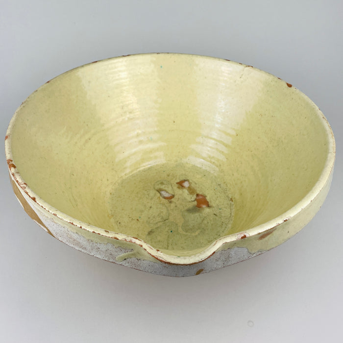 Antique XL French terracotta tian bowl from Provence with a wide flared rim, deep tapered body, pale yellow glazed interior, and warm ochre unglazed exterior. Irregular pale glaze remnants around the outer rim and natural surface wear enhance the handmade provincial character, making the bowl a strong centerpiece for farmhouse decor or French country decor.