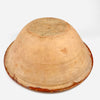 The underside of the antique French tian bowl exposes its unglazed terracotta construction, broad rounded body, circular foot, and wheel thrown ridges. Surface deposits, scratches, clay discoloration, and small edge losses are consistent with long practical use, while the substantial handmade form reinforces its appeal as authentic French country pottery.