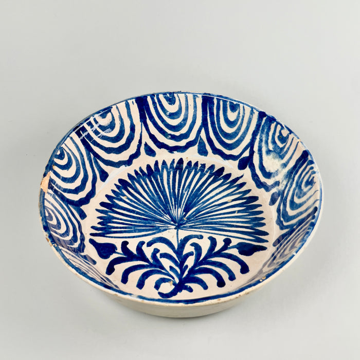 Large Antique Spanish Fajalauza lebrillo bowl from Granada featuring a cobalt hand-painted palm tree in the center and rhythmic wave motifs around the rim, photographed from the front to showcase its full decorative surface and historic Andalusian ceramic design.