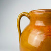 Spanish two handle terracotta olive jar, large decorative vessel with glossy amber glaze and natural drip lines where glaze meets exposed terracotta. The wide mouth and substantial body allow styling as a floor vase for tall branches or as a decorative storage jar, aligning with Mediterranean decor and coastal decor palettes.