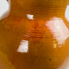 Spanish terracotta olive jar with two handles, glazed upper body and raw terracotta lower section showing strong tactile contrast. The glaze drips and tonal shifts read as kiln-fired variation rather than painted design, a detail collectors seek for wabi sabi decor and organic modern decor where imperfect surfaces add depth.