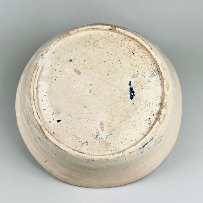 Backside of antique Spanish lebrillo showcasing the unglazed terracotta base with subtle wheel rings and aged firing marks, highlighting its hand-thrown craftsmanship and authentic Andalusian origins from the 1800s.