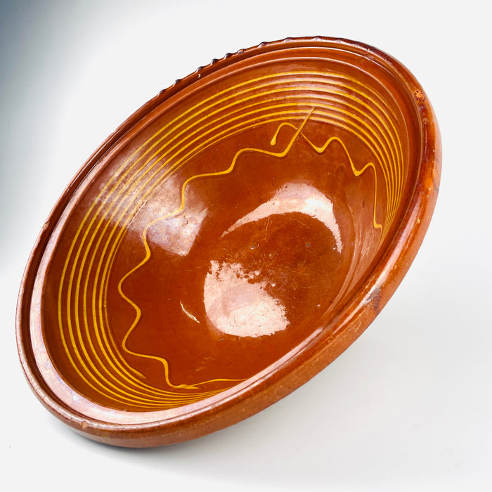 This large antique French terracotta bowl combines a wide open tian form with a warm glazed interior, delicate yellow line decoration, and a pale unglazed body. The balanced proportions and rustic surface make the early 20th century Southern French pottery suitable as a fruit bowl, table centerpiece, or sculptural accent within farmhouse decor.