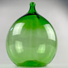Large French dame jeanne in translucent bottle-green glass, with a rounded 25 L body, elegant tapering shoulders, and a narrow neck above the original utilitarian wine-vessel form. Display this vintage demijohn beside a console or fireplace, or use it with tall branches in French country decor, farmhouse decor, or Mediterranean decor.