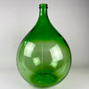 French dame jeanne bottle dating to the early to mid 20th century, formed in translucent emerald-green glass with a broad bulbous body, tapering shoulders, narrow neck, and reinforced mouth. Estimated at 25 L, this oversized demijohn can serve as a floor vase for tall branches, dried grasses, seasonal foliage, or sculptural display.