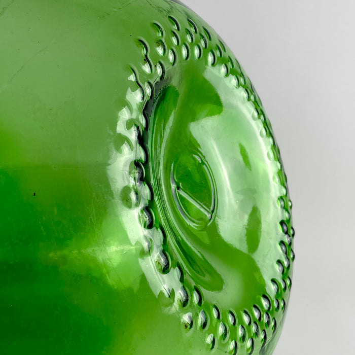 Oversized emerald glass vase in the form of a vintage French demijohn, featuring a broad bulbous body, sloping shoulders, narrow neck, and reinforced double-ring mouth. The translucent glass catches natural light and complements wicker, terracotta, linen, and old French pottery in organic modern decor, wabi sabi decor, and Mediterranean decor.