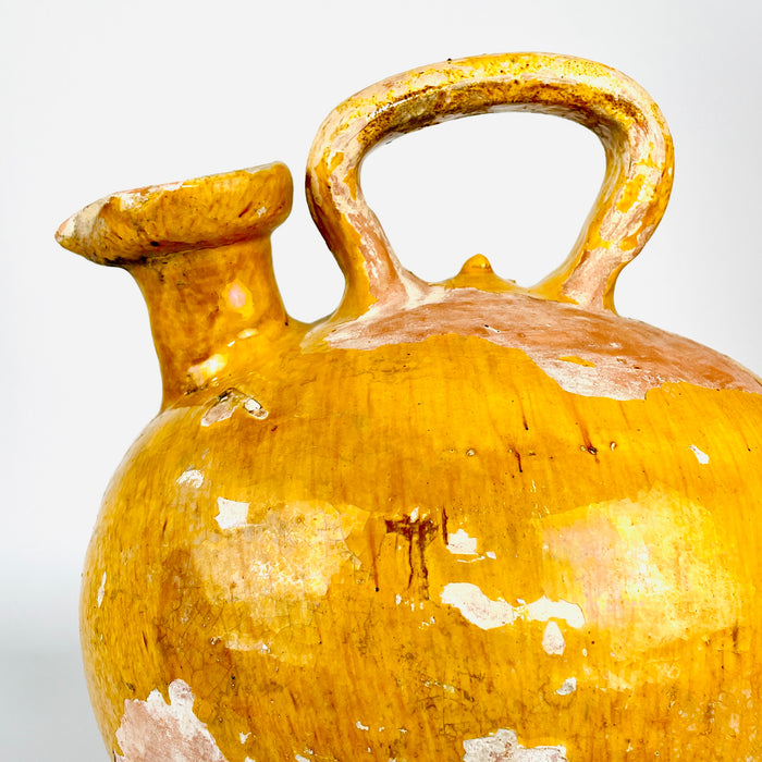 Overhead view of a very rare French cruche showing the relationship between its broad pinched mouth, strong handle and full ovoid terracotta body. The wide glazed opening and unusual asymmetrical construction distinguish this large yellow pottery water jug from conventional narrow-spouted gargoulettes.