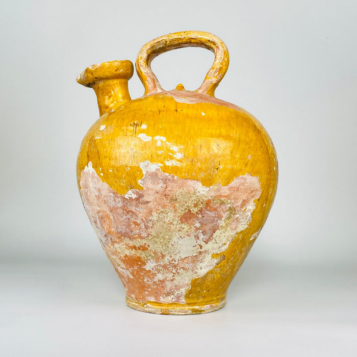 Large antique Wabi Sabi French yellow pot dating to the early 19th century, hand thrown in terracotta in Provence and covered with mustard glaze. The sculptural 38 cm cruche has a rounded ovoid body, high overhead handle and extremely rare broad pinched spout, creating a distinctive gargoulette water-jug silhouette for French country decor.