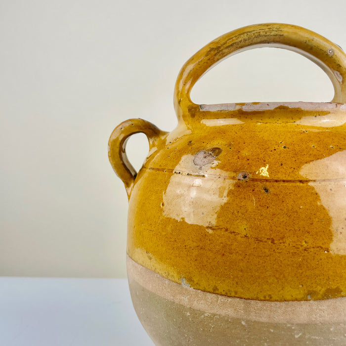 Rear perspective of the antique French gargolette showing its arched handle and lid tied with string, revealing patina from generations of use. Complements rustic, cottage, or Mediterranean farmhouse settings beautifully.