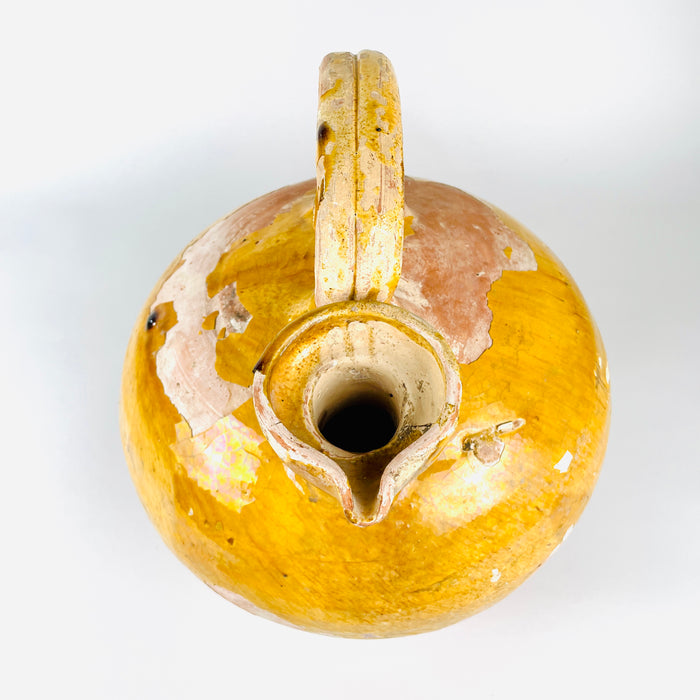 an early 18th-century French yellow pot with a full earthenware body, high applied handle and extremely uncommon broad pinched spout. The remaining ochre glaze varies from mustard to amber, while large rose-terracotta areas give the gargoulette an authentic rustic home decor presence.