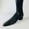 Antique French tailor’s mannequin leg in black painted solid wood, defined by a high narrow calf, articulated boot section and block heel. Extensive scuffs, paint losses and worn edges record its practical nineteenth century use, while the freestanding shape gives this rare fashion trade fragment a strong presence in maximalist decor.