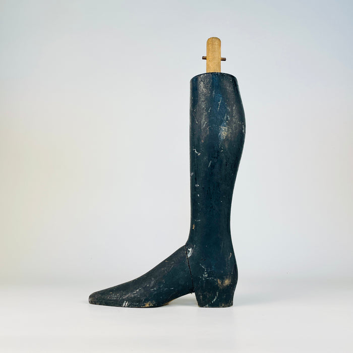 Single wooden lower leg from a nineteenth century French tailor’s mannequin, carved with an elongated boot, low shaped heel and refined taper from calf to ankle. The black paint has developed extensive rubbing, losses and marks, and the ankle join remains clearly visible. A distinctive collectible for oddities decor and fashion history collections.