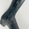 Surface detail of a nineteenth century French tailor’s mannequin leg shows scattered small holes, old scratches, paint abrasion and an open crack through the ankle and heel junction. Pale solid wood is exposed beneath the black painted finish. These condition details remain integral to the antique trade object’s character in dark academia decor.