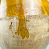 Late 19th century French confit jar in terracotta, with a broad rounded mouth and mustard yellow glaze continuing across the interior. Small chips and glaze losses around the rim expose the clay beneath, while fine crazing and firing speckles record the vessel’s age and handmade provincial pottery character.