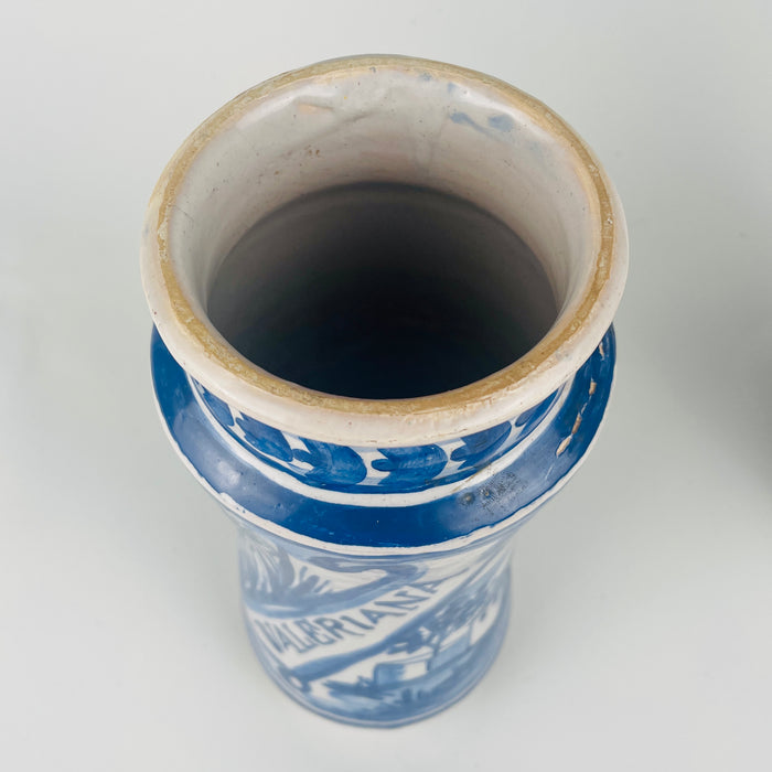 Spanish albarello apothecary jars in white faience with cobalt blue decoration and prominent banner lettering, sized for impactful shelf styling. The pair complements Mediterranean decor kitchens, coastal decor dining rooms, and eclectic vintage home decor, functioning as ceramic containers for cooking utensils, paint brushes, or dried flowers.