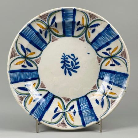 Antique Spanish Manises plate, tin-glazed earthenware with cobalt blue, green, and ochre floral brushwork, full front view, ideal as Mediterranean wall decor or rustic tabletop centerpiece.