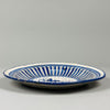 Historic Spanish ceramic plate with stylized bird center, repeating radial pattern, and tin-glazed surface, crafted in Manises circa 1880, used today as wall art.