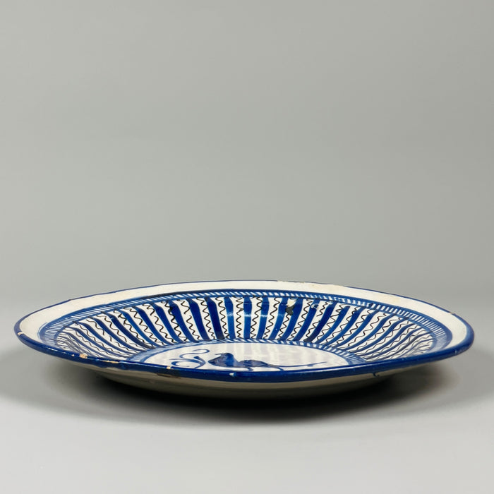 Historic Spanish ceramic plate with stylized bird center, repeating radial pattern, and tin-glazed surface, crafted in Manises circa 1880, used today as wall art.
