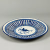 Overhead view of Spanish Manises faience plate, cobalt bird motif framed by geometric zigzag border, typical of Hispano-Moresque ceramic influences in 19th-century Valencia.