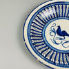 Cobalt blue decorative bird plate from late 19th-century Spain, crafted in Manises using tin-glazed ceramic techniques, with central avian figure and surrounding zigzag brushwork for wall decor.