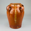 Red clay vessel from Toledo, Spain with looped handles and irregular glaze drips, viewed head-on to highlight handmade form, decorative surface, and traditional firing characteristics, ideal for rustic home decor or ceramic collectors.