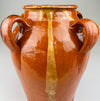Red clay vessel from Toledo, Spain with looped handles and irregular glaze drips, viewed head-on to highlight handmade form, decorative surface, and traditional firing characteristics, ideal for rustic home decor or ceramic collectors.
