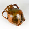 Antique Spanish glazed terracotta jar, where broad areas of unglazed orange red clay contrast with glossy honey and olive brown glaze. The visible wear, drips and handmade texture emphasize the nineteenth century orza vessel’s rural character and make it compatible with Mediterranean decor and farmhouse decor.