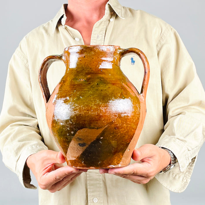 Traditional Spanish orza storage jar in glazed terracotta, with a broad open mouth and a dark honey brown glazed interior showing circular wheel marks from hand production. The nineteenth century Castilian pottery vessel has twin loop handles and a rounded body, making it a strong antique vase or sculptural jar for rustic home decor.
