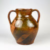 Antique Spanish glazed terracotta vase from nineteenth century Castile, formed as a traditional two handled orza pottery jar. The rounded red clay body has a short neck, open mouth, amber brown glaze across the upper section, exposed terracotta below, and age worn patina suited to Mediterranean decor or farmhouse decor.