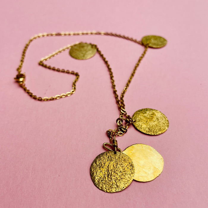Hand-assembled gold-tone chain necklace with hammered coin discs. Designed as Mediterranean-inspired jewelry for modern wardrobes. Lightweight and versatile, it can be styled as a standalone statement or layered with other chains