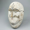 African carved wood tribal mask with white pigment, inspired by ceremonial masks from the Fang and Kwele peoples of Central Africa, shown upright with stylized features and drilled holes for wall mounting or decorative use in rustic interiors.