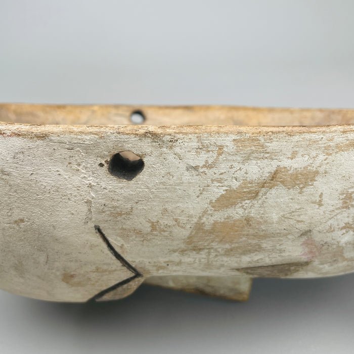 Mask displayed at a slight angle to highlight cheek detail, mouth line, and incised patterning, showcasing craftsmanship typical of African ceremonial art adapted for decorative wall presentation.