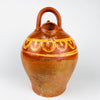 Antique Spanish folk pottery vessel in the form of a botijo, made in terracotta and decorated with hand painted yellow lines and repeated curved motifs over a glazed brown ground. The lower half is left in natural clay, creating contrast between glossy glaze and matte porous earthenware. Measuring approximately 33 cm high, this water jug has an estimated capacity of about 3 L and can be displayed as a decorative terracotta vessel in farmhouse decor, Mediterranean decor, or vintage home decor.