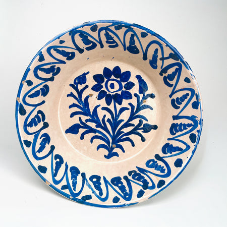 Antique Spanish Fajalauza lebrillo bowl from Granada, dating to the 19th century, made in tin glazed terracotta with a warm cream-white ground and bold cobalt blue decoration. The center shows a hand painted floral spray, while the wide inner wall carries a repeating blue border. This Granada pottery bowl works as a decorative bowl, table centerpiece, or wall hanging ceramic for Mediterranean decor, rustic home decor, and vintage home decor.