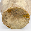 Antique French confit pot held to demonstrate its substantial scale, measuring 26.6 cm high and 26 cm wide handle to handle with a weight of 2.6 kg. The large rounded terracotta body, intact twin handles, mustard yellow glazed upper section and tapered raw-clay base create a strong sculptural presence for French country decor or farmhouse decor.