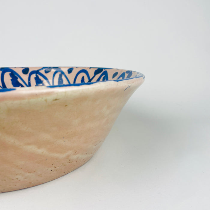 Antique Spanish Fajalauza bowl in glazed terracotta from Granada, measuring 31.5 cm wide and 9.9 cm high, with a deep open profile and a central cobalt blue floral motif. The brush-painted border around the inner wall gives the bowl strong graphic definition, while the underside reveals workshop wear and kiln-age character. This lebrillo bowl serves well as a decorative bowl, centerpiece bowl, or wall display ceramic in rustic home decor and wabi sabi decor.