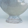 French pottery decorative bowl with a substantial rounded body and sculpted loop handle, finished in a softly weathered white glaze over terracotta earthenware. The lidded pedestal tureen has a strong architectural silhouette and can anchor a sideboard, mantel, console, or Mediterranean decor arrangement.