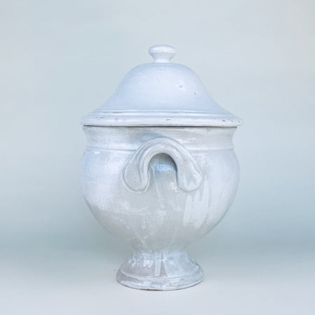 Large vintage French soup tureen with lid, made from substantial white glazed earthenware and raised on a flared pedestal base. Its rounded body, paired side handles, and domed cover create a sculptural decorative bowl for a dining room sideboard, kitchen island, or collected French country decor display.
