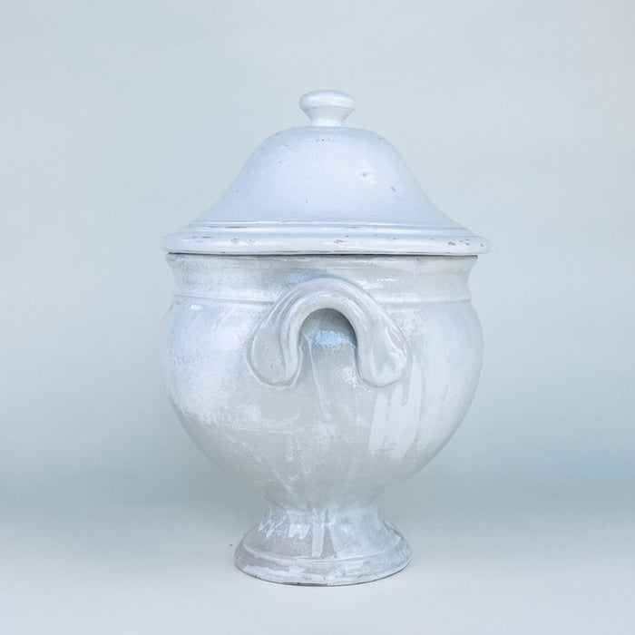Large vintage French soup tureen with lid, made from substantial white glazed earthenware and raised on a flared pedestal base. Its rounded body, paired side handles, and domed cover create a sculptural decorative bowl for a dining room sideboard, kitchen island, or collected French country decor display.