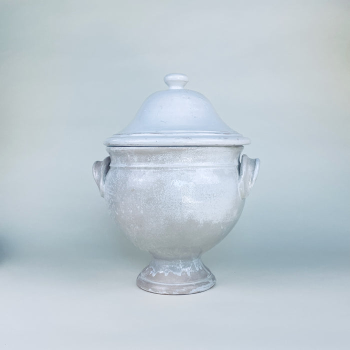 White ceramic pedestal tureen with its domed lid removed, revealing the deep glazed interior and substantial rim of the French earthenware body. The two handled lidded bowl retains a sculptural serving form while its timeworn finish makes it especially suited to decorative storage, dried botanicals, or rustic home decor.
