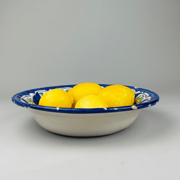 Image showing full plate with stand from eye level, placing focus on overall color composition and polychrome border design, perfect for listing styling or folk art interior design uses.

